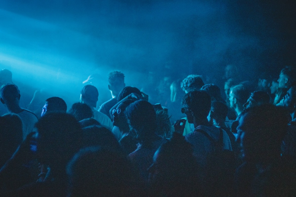 A club crowd lit in cool blue haze.